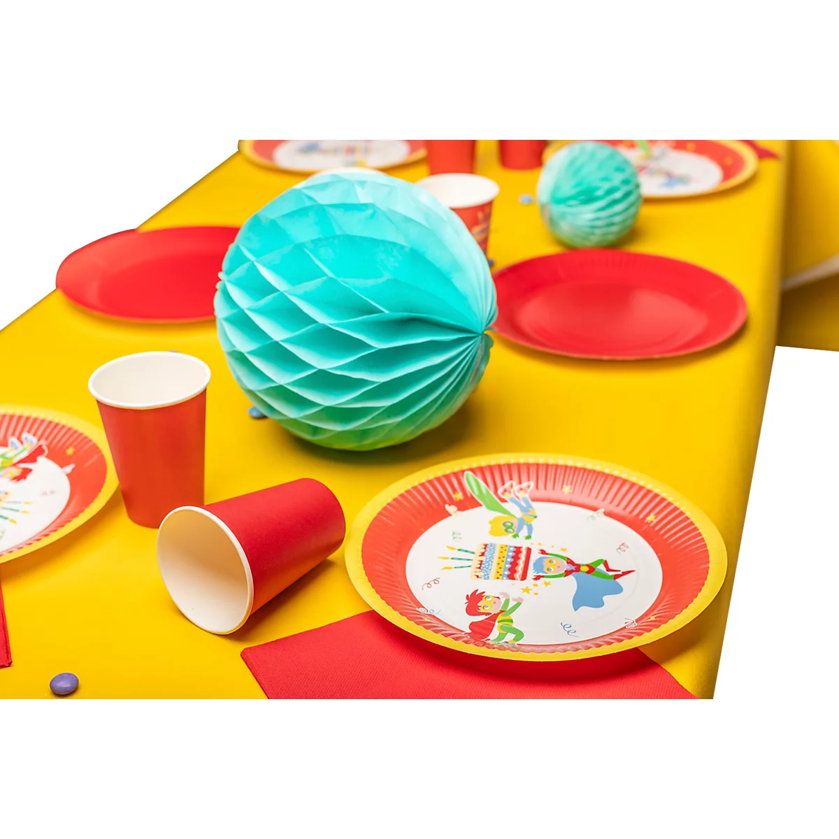 Une table de fête avec des assiettes, des gobelets, une nappe et un ballon en papier rouge, jaune et turquoise.