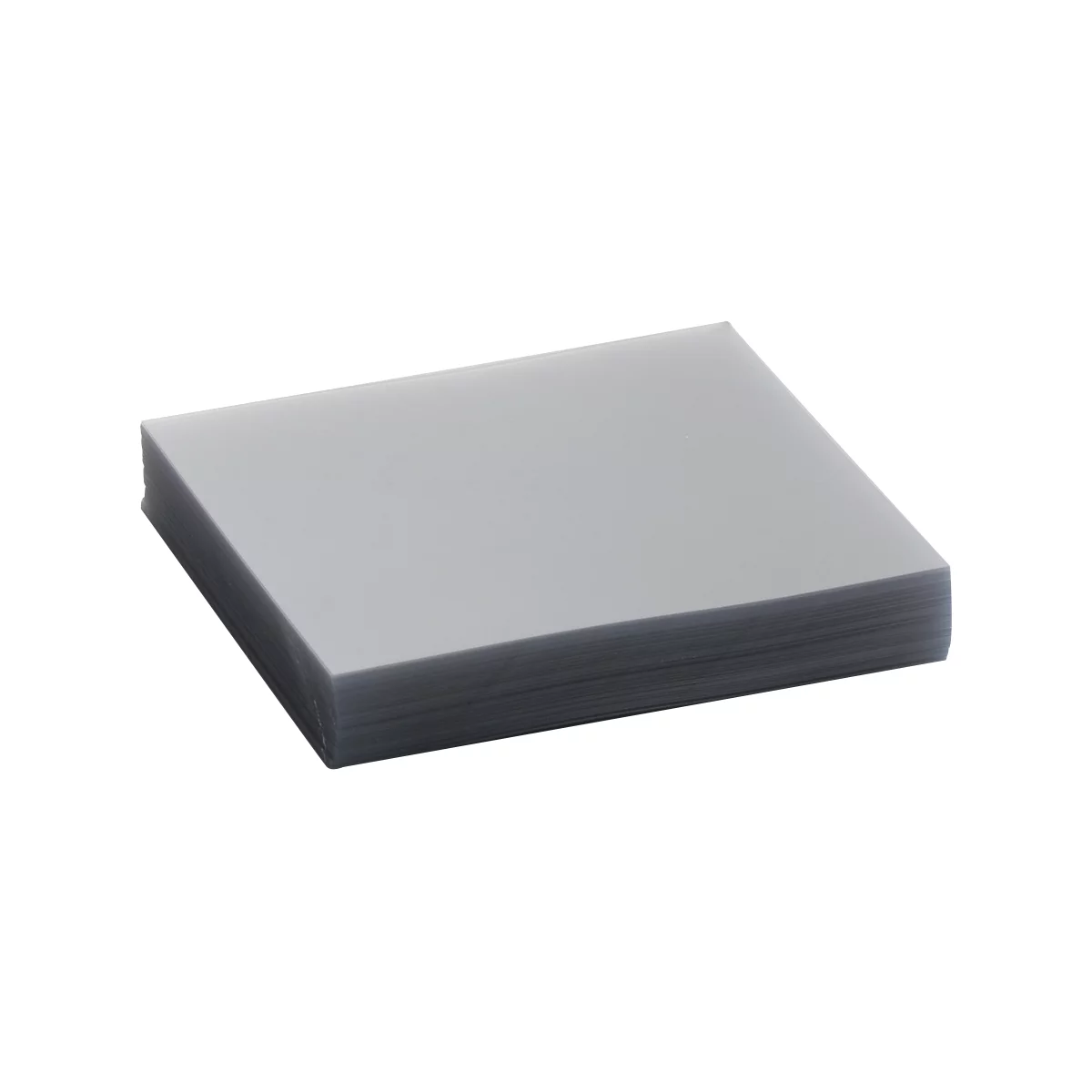 A stack of gray sheets, presumably paper or film, lying on a light surface.
