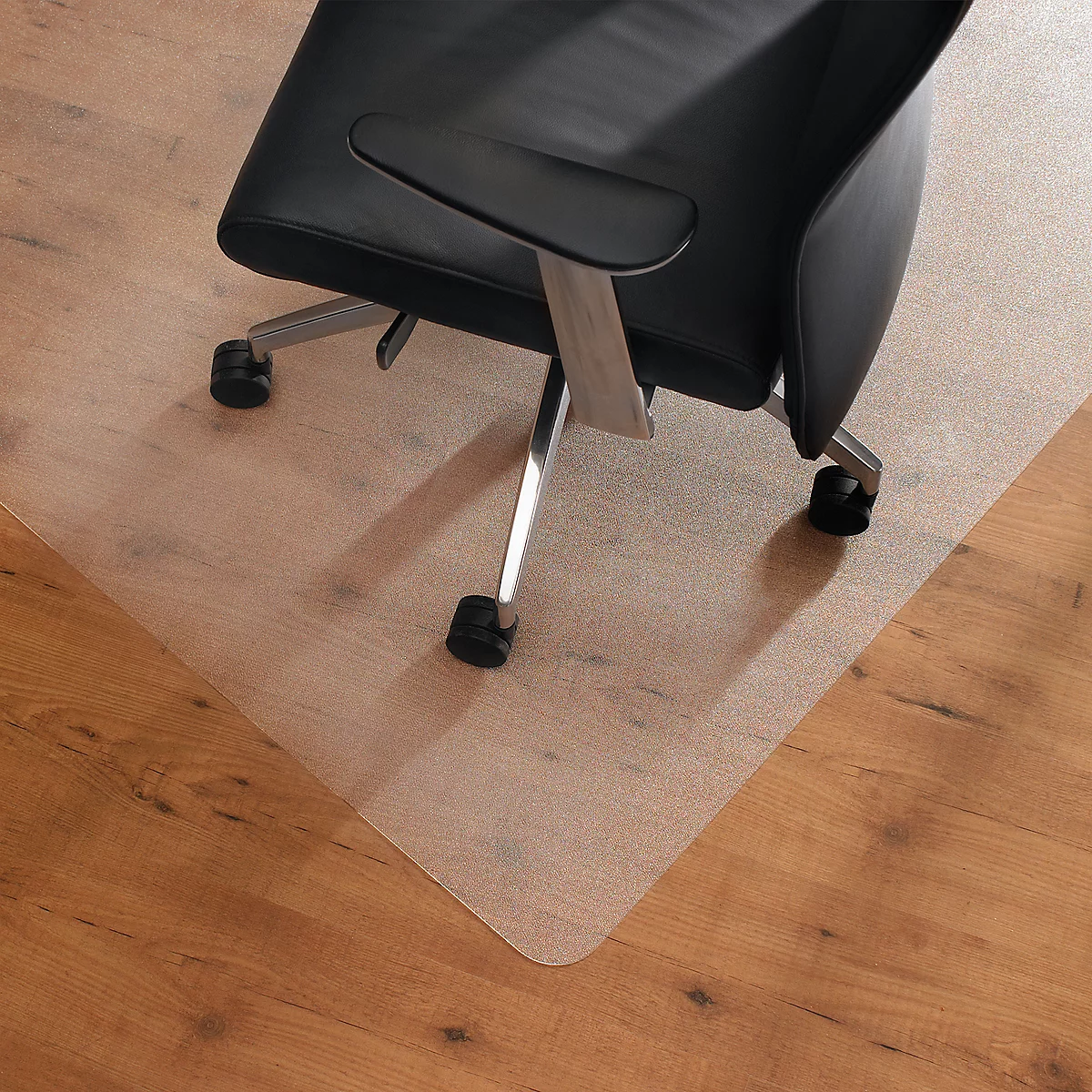 Office chair on a transparent floor protection mat on a wooden floor.