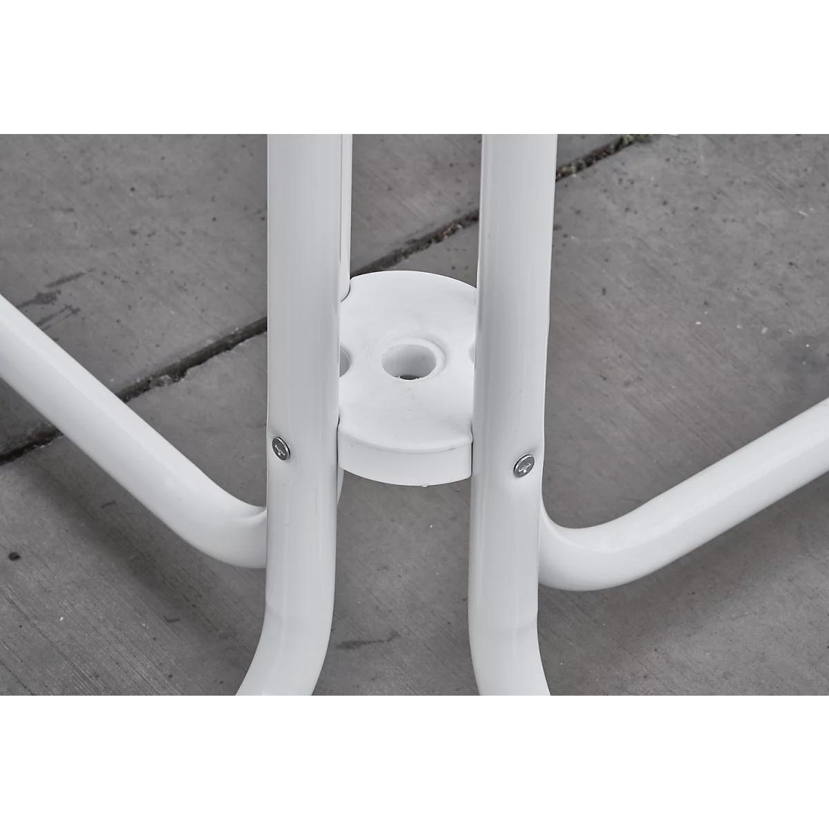 Detail of white chair leg connection. Round tubes and a white disc with screws.