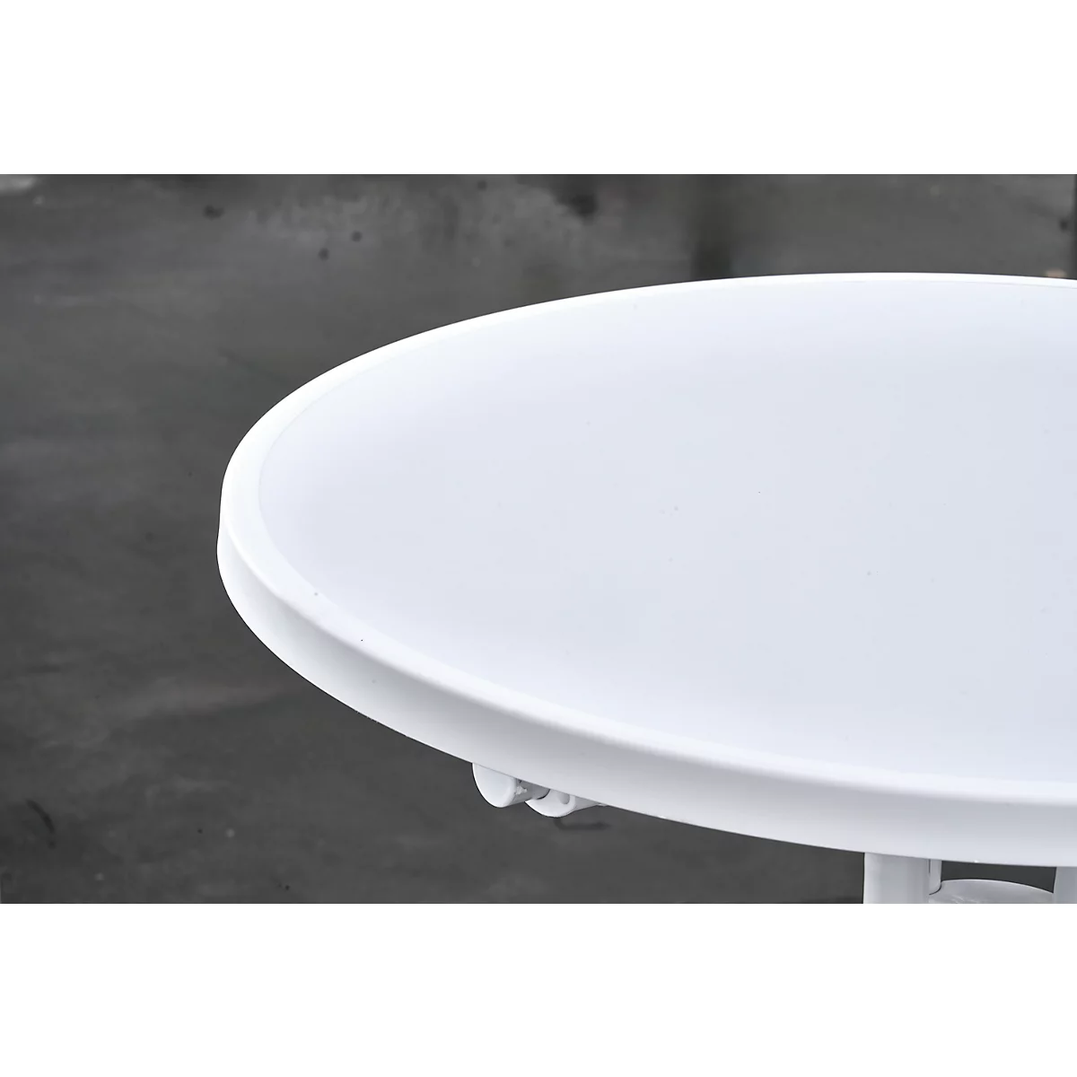 Close-up van een witte, ronde tafel. Het tafelblad is glad en glanzend, de achtergrond grijs.