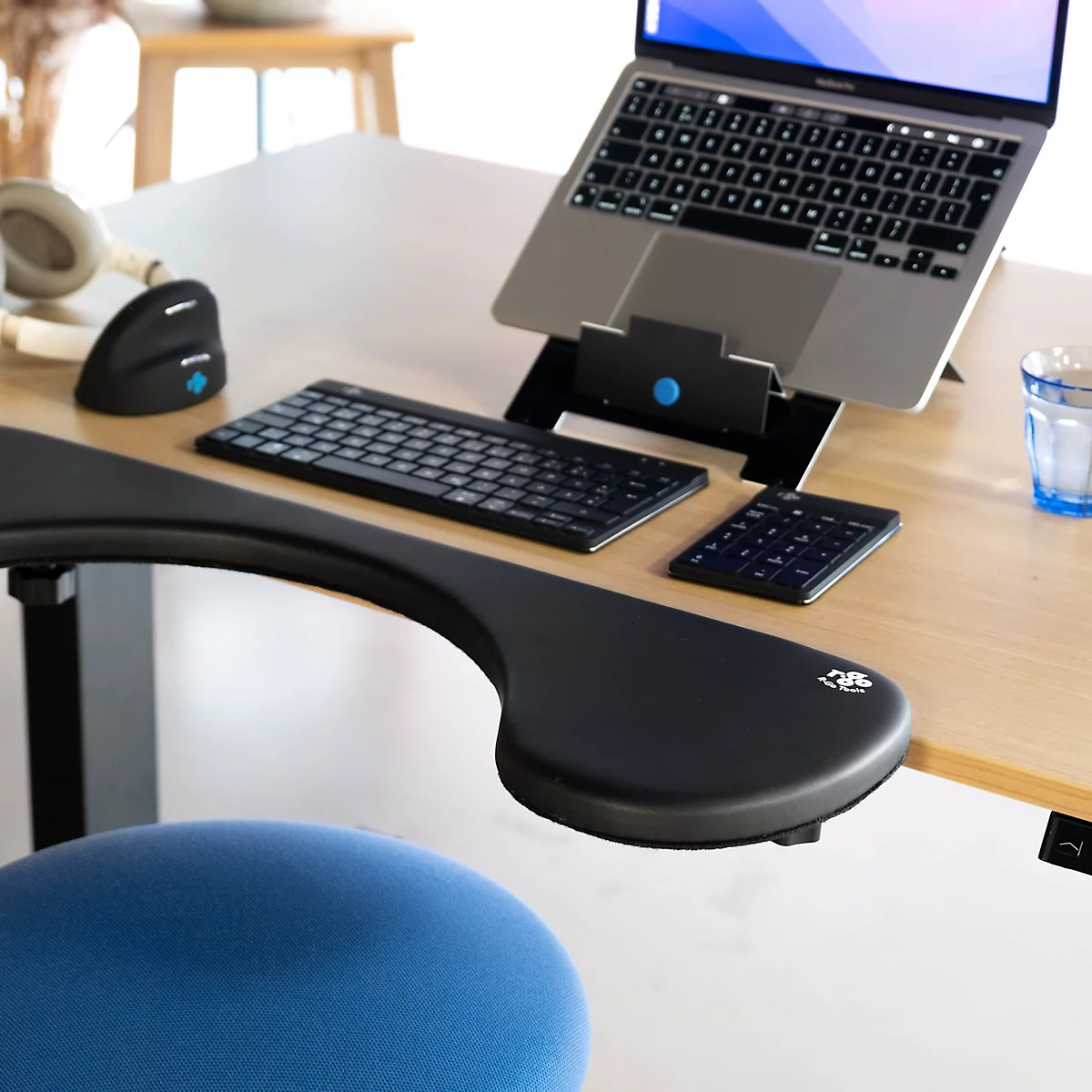 Desk setup with a laptop, external keyboard, armrest, and mouse.