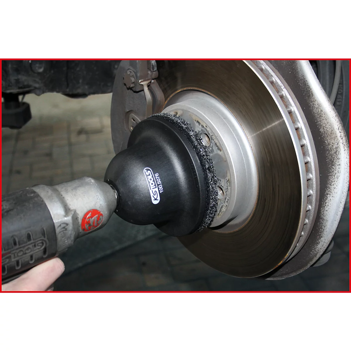 Nahaufnahme einer Bremsanlage, wobei ein Werkzeug auf die Bremsscheibe aufgesetzt wird. Auf dem Werkzeug steht „KS TOOLS“.