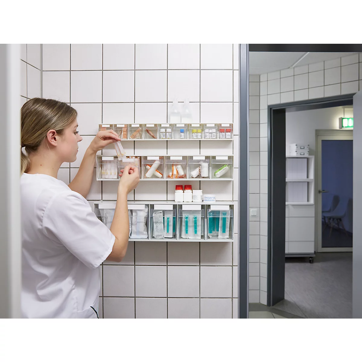 Infirmière prenant des médicaments dans une étagère de conteneurs à médicaments dans un hôpital.