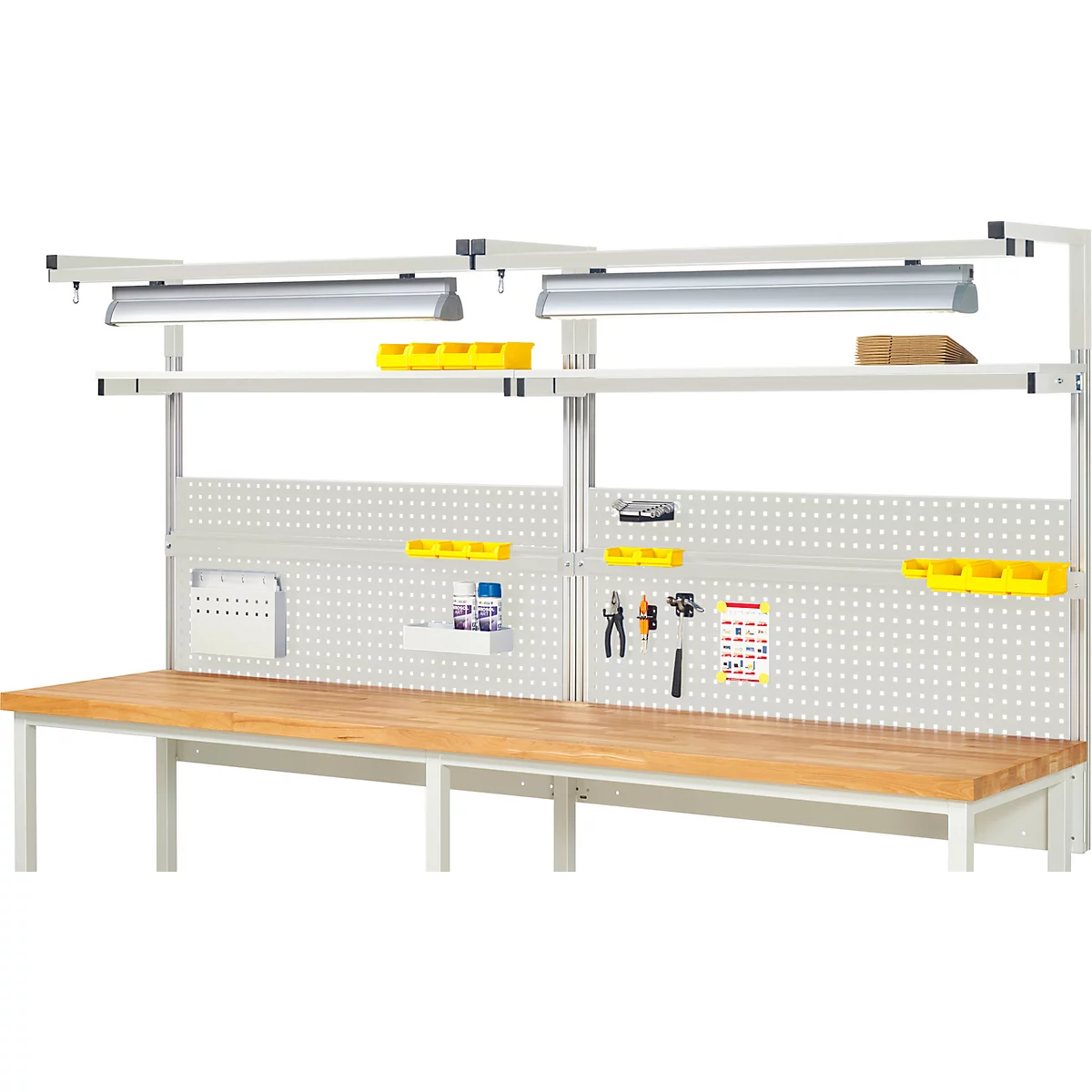Établi avec panneau perforé, étagères et éclairage. Espace de travail pour l'artisanat ou l'atelier avec des outils. Plateau en bois.