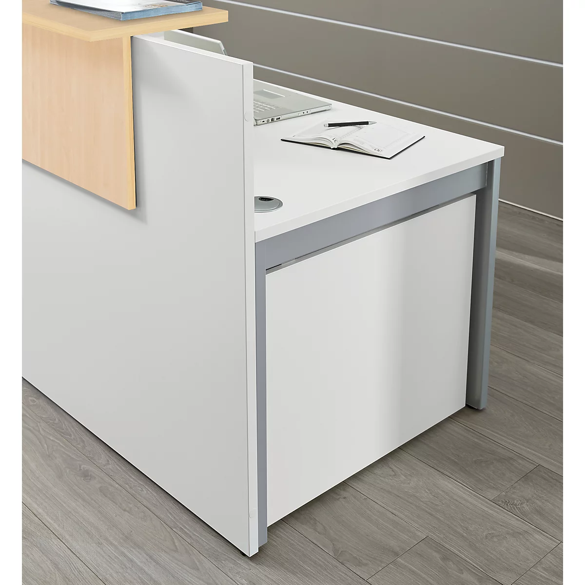 Moderne witte receptiebalie met een licht houten opzetstuk op een houten vloer.
