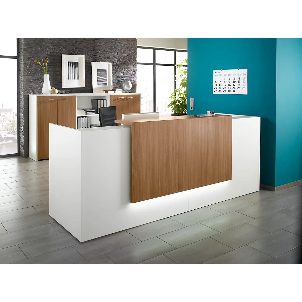 Modern reception desk in white and wood look with lighting. Office with cabinet wall in the background.