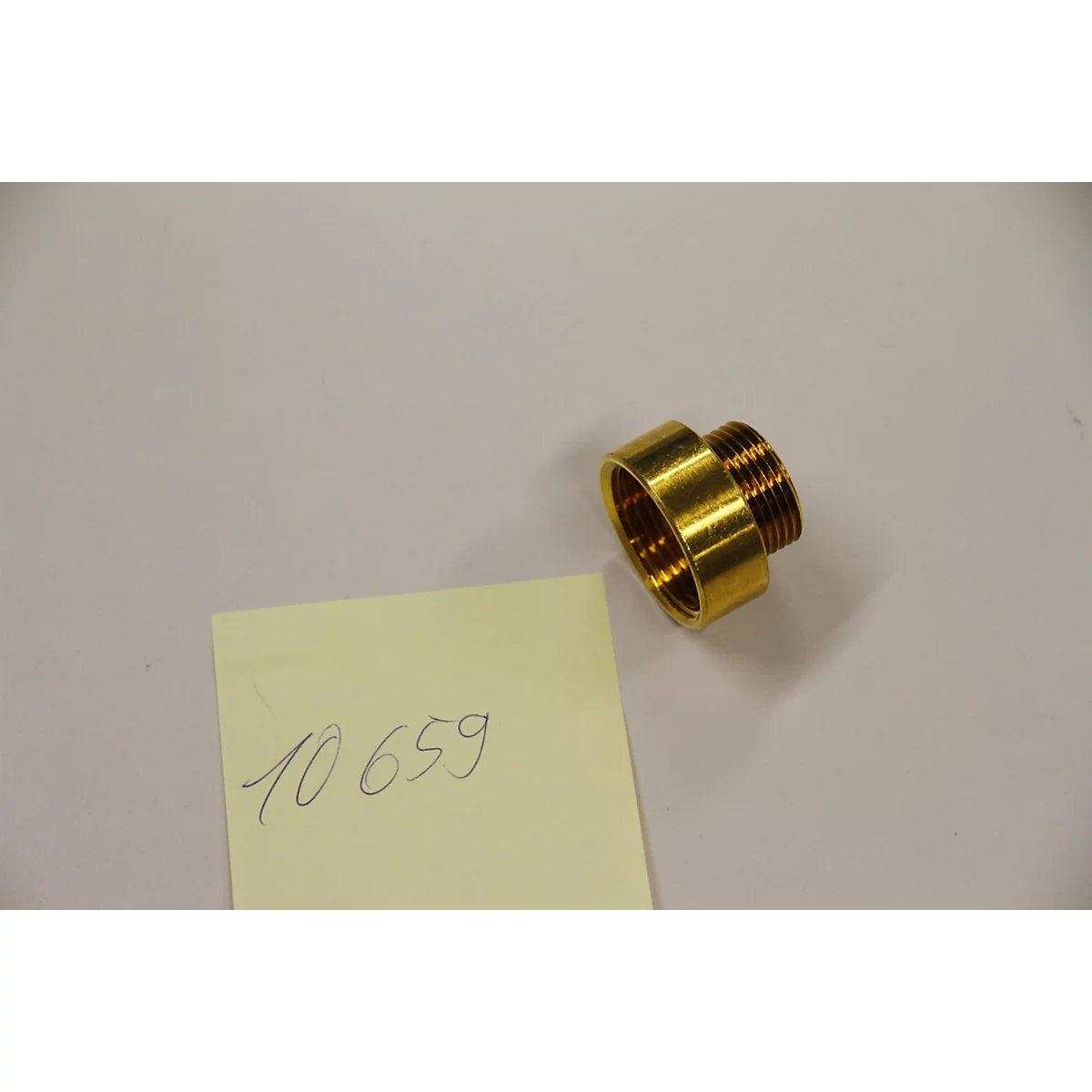 Raccord doré à côté d'une note jaune portant l'inscription manuscrite "10 659".