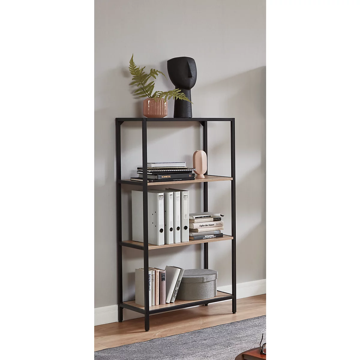 Schwarzes Metallregal mit Holzregalen, dekoriert mit Büchern, Ordnern, Pflanzen und einer schwarzen Skulptur.