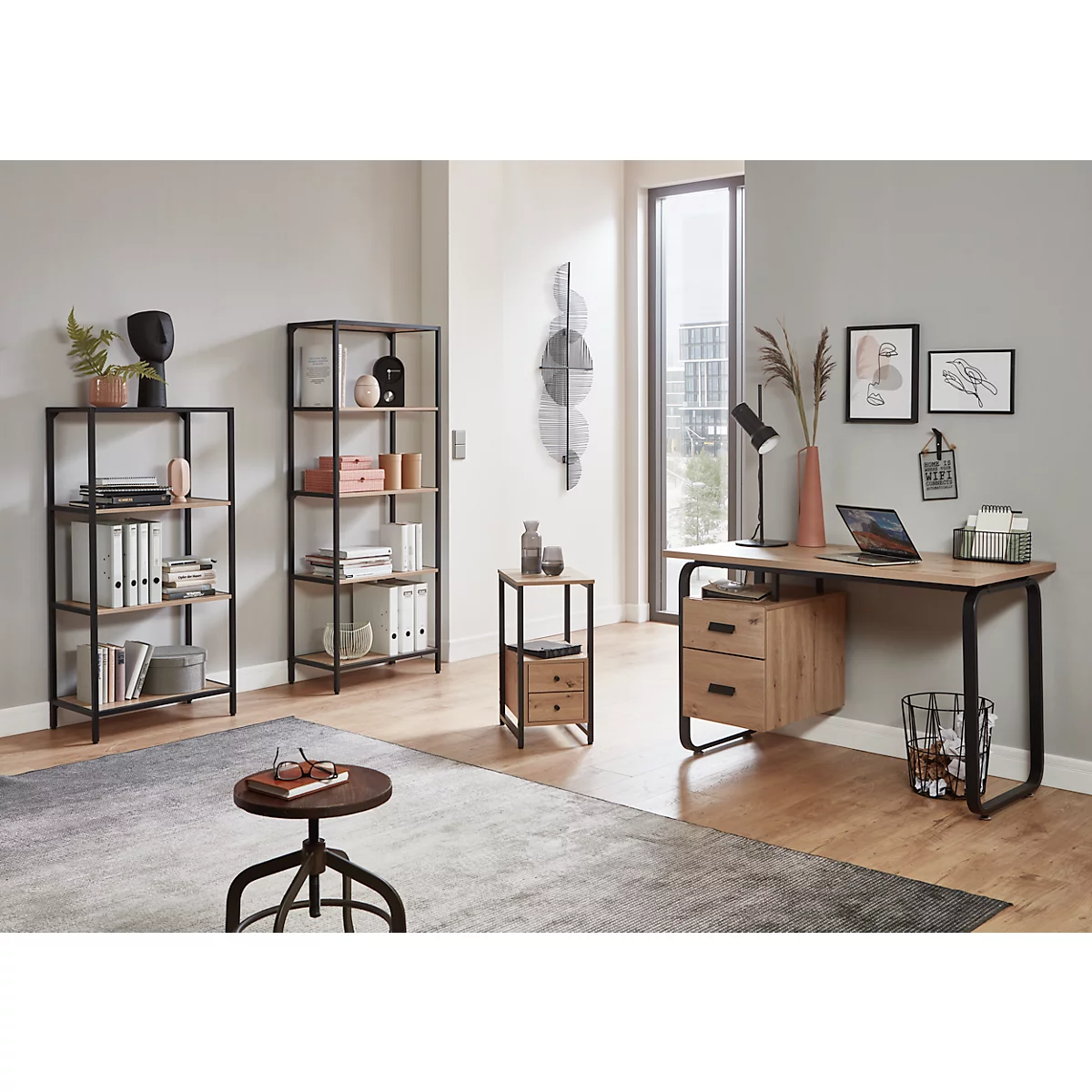 Büroeinrichtung mit Schreibtisch, Regalen und Zubehör. Helle, moderne Atmosphäre. Auf dem Schreibtisch steht ein Laptop.