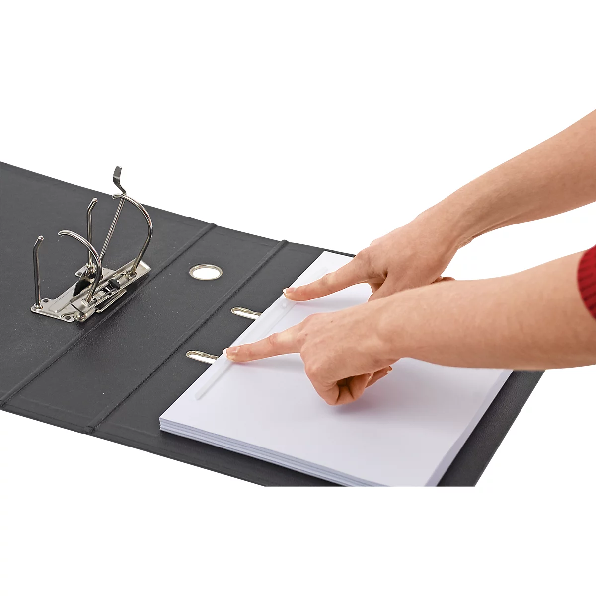 Mains pointant vers du papier dans un classeur noir, fermoir métallique.