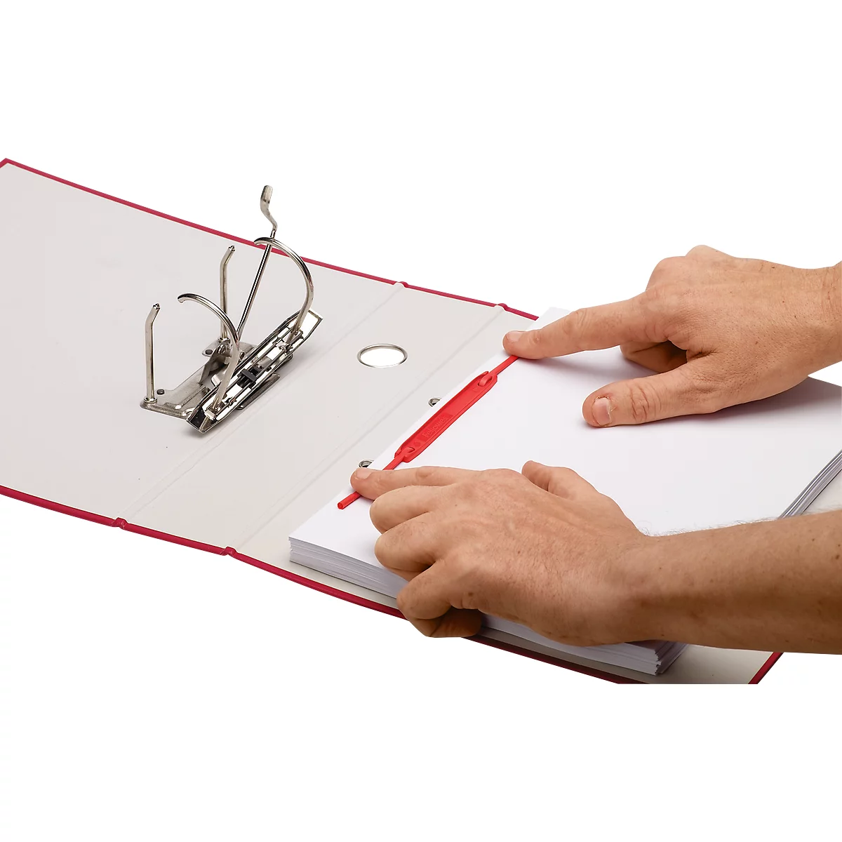 Mains tenant un classeur avec une fermeture rouge et du papier. Le classeur est ouvert, le papier est en train d'être inséré.