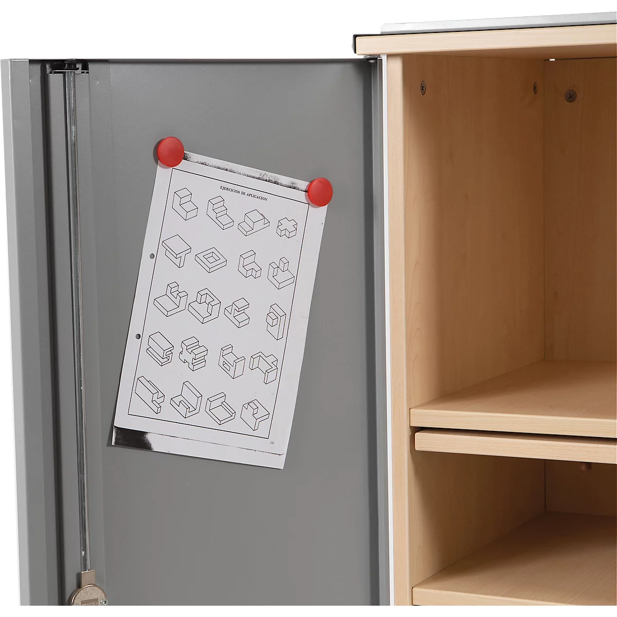 Open cabinet door with a drawing attached with red magnets. Next to it, the empty interior with shelves can be seen.