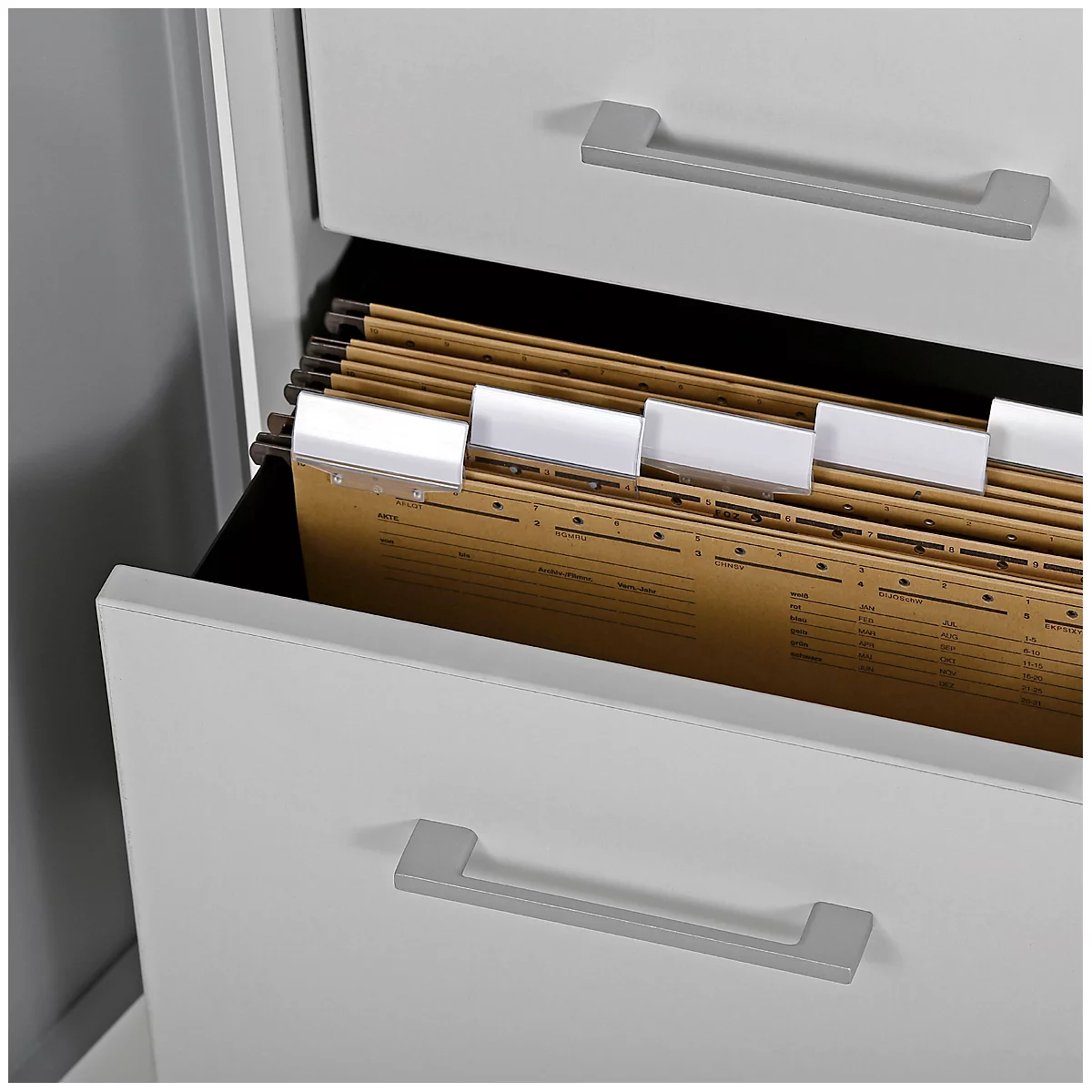 Open drawer of a white filing cabinet filled with brown documents and white tabs.