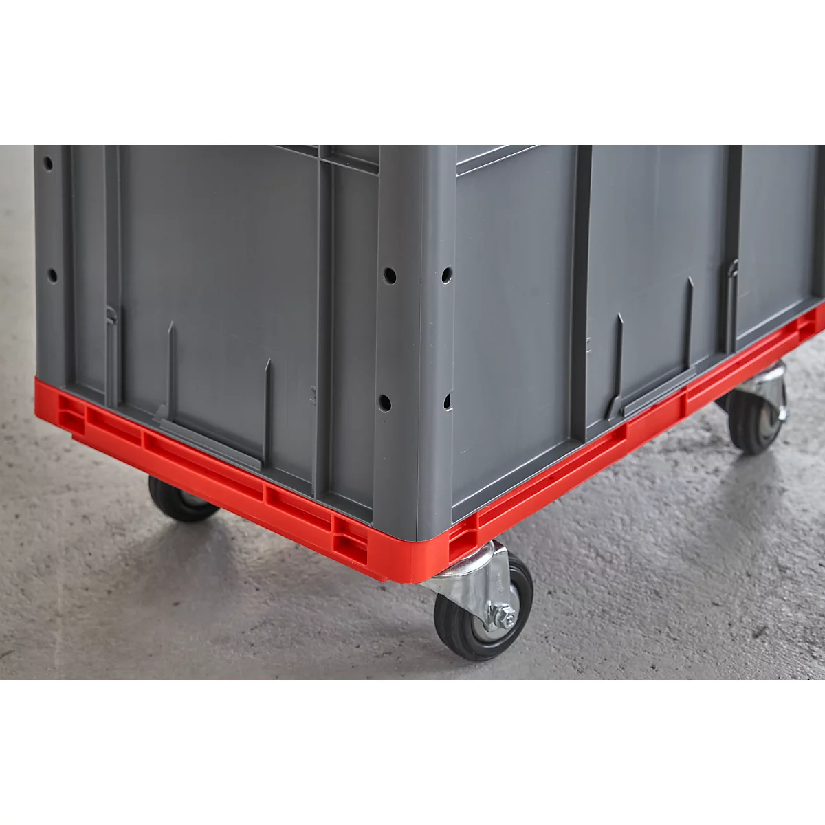 Grey transport box with red base on wheels. Detail view.