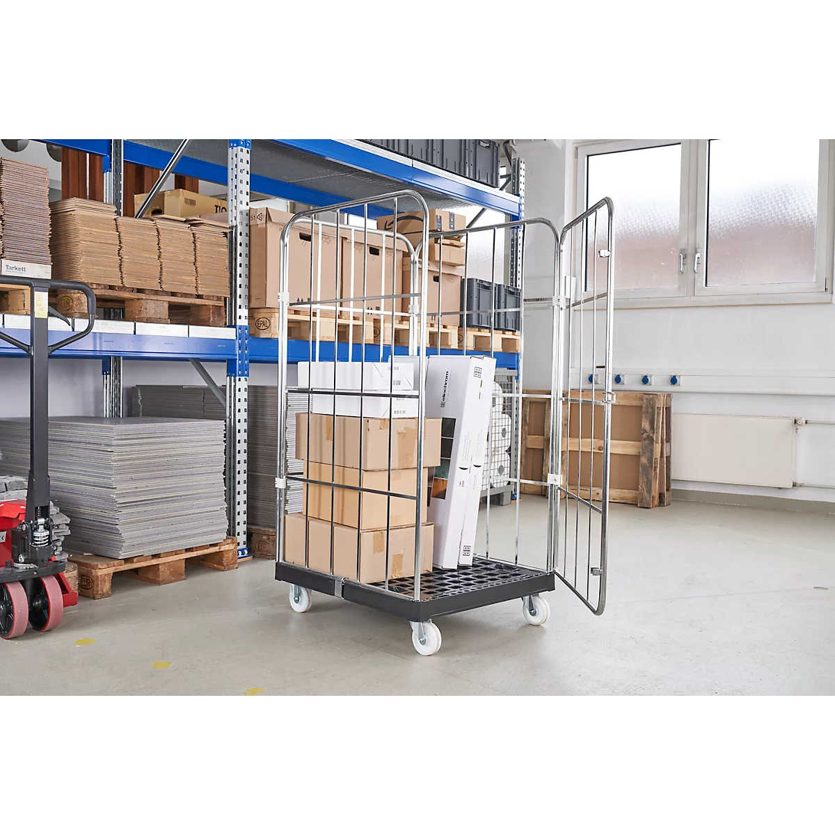 Chariot à roulettes avec des boîtes dans un entrepôt. Porte ouverte, chariot rempli, derrière d'autres étagères.