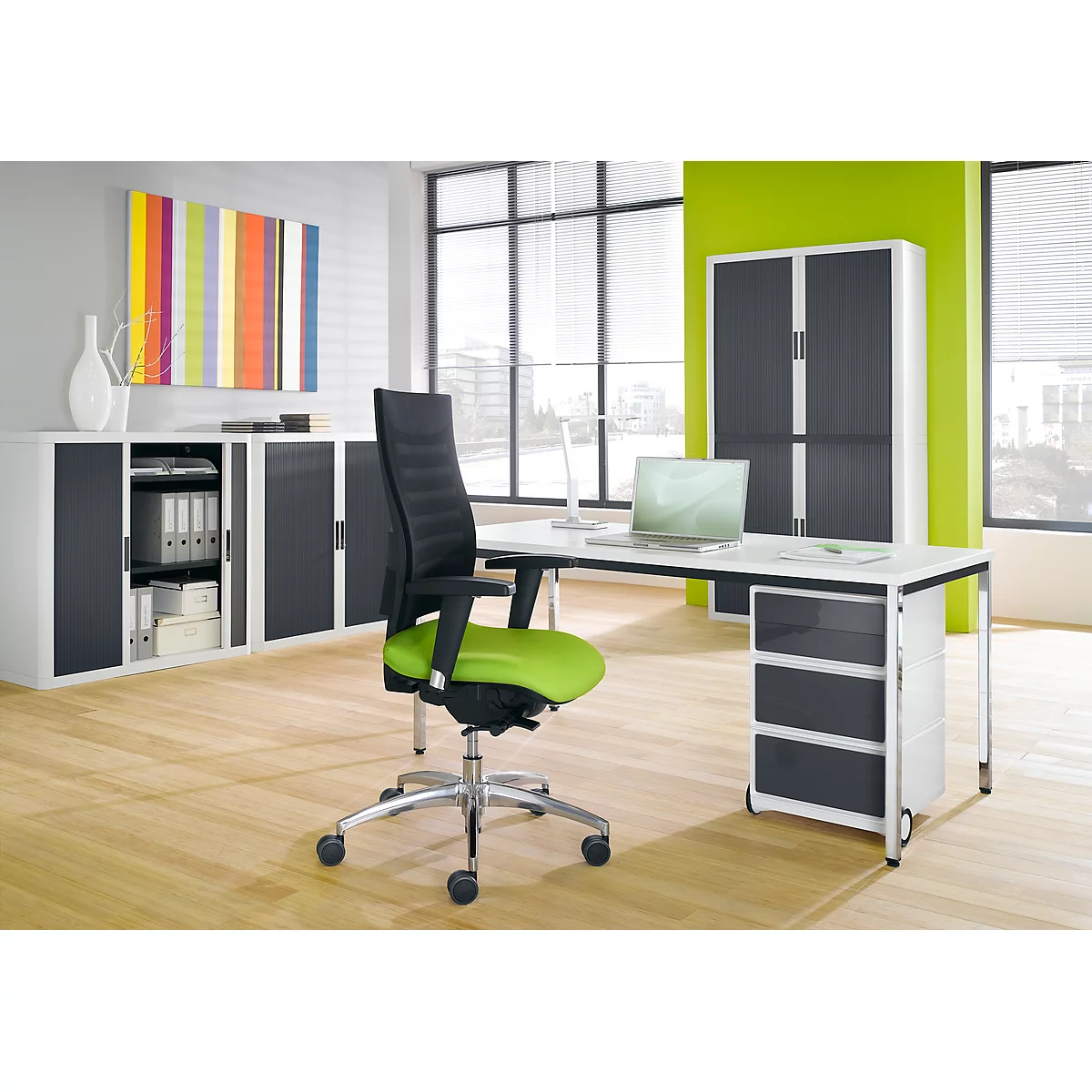 Office space with a modern desk, chair, wall unit, and colorful artwork. Bright ambiance, plenty of daylight.