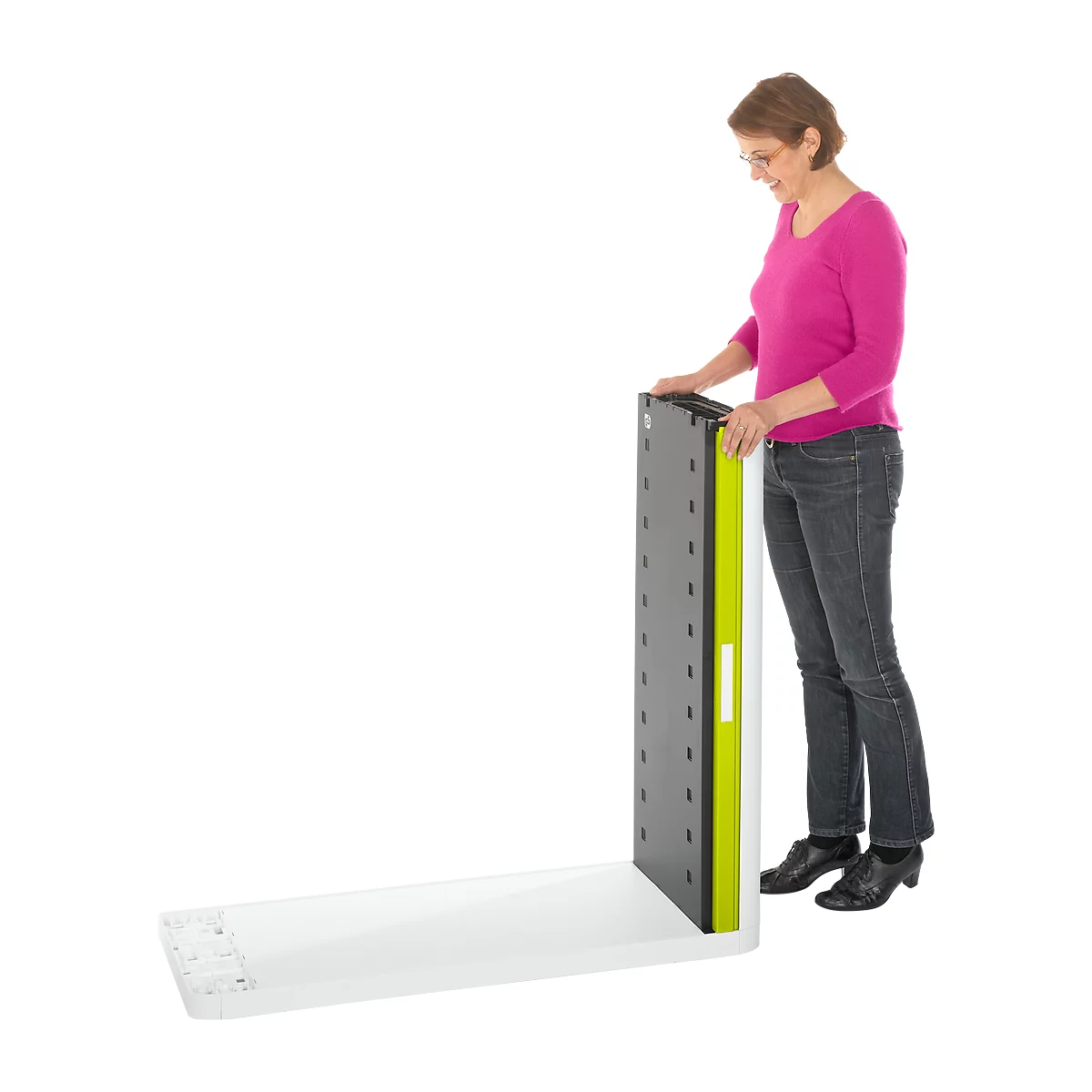 A woman in jeans and a pink shirt holds a vertical gray board with green and white accents.