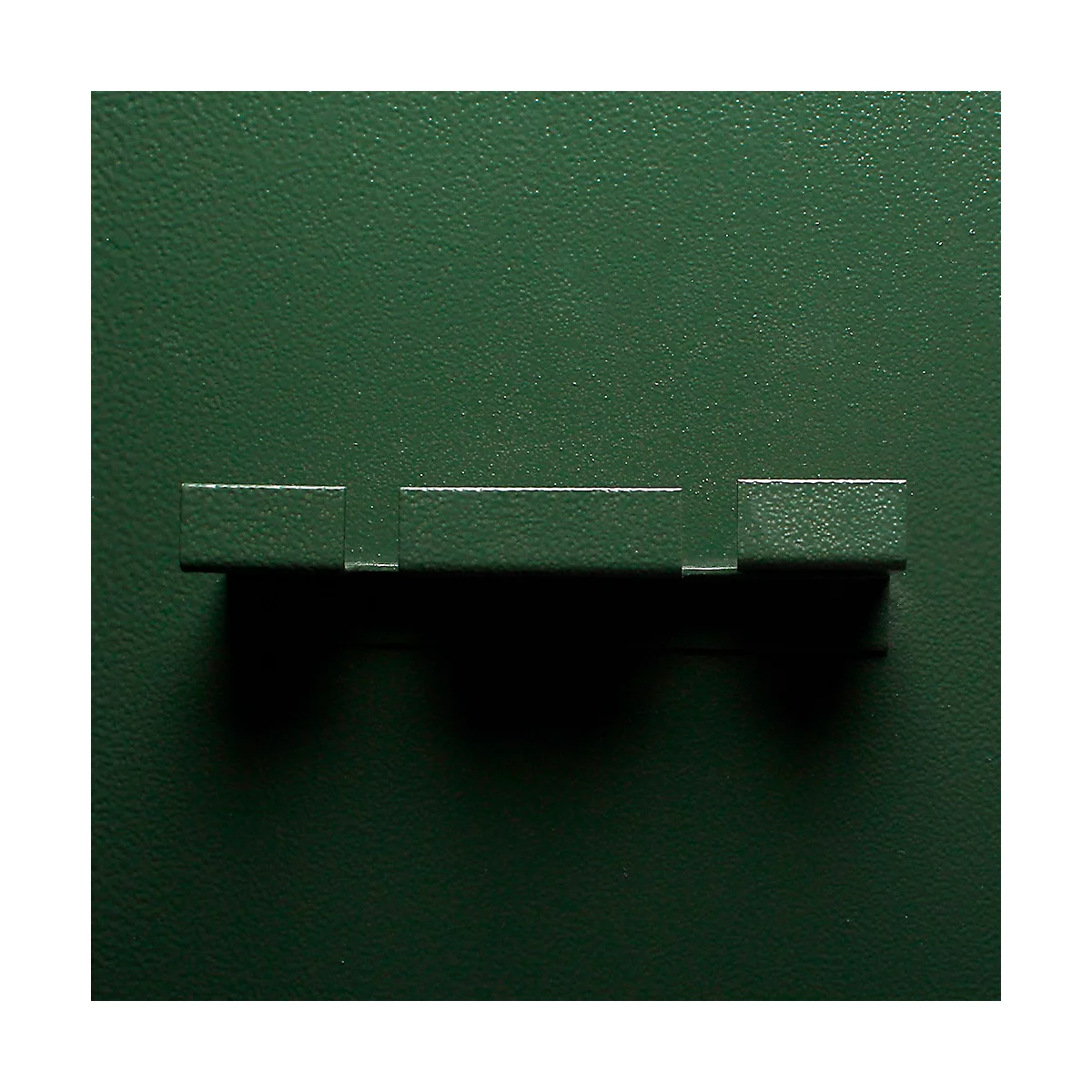Dark green background with a horizontal, rectangular detail with three sections. The surface appears to be slightly textured.