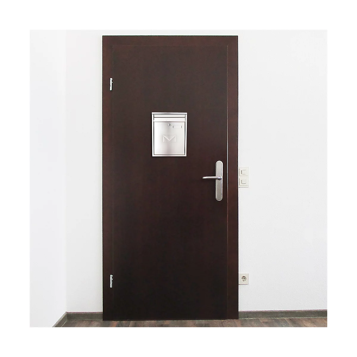 Porte marron foncé avec boîte aux lettres et poignée argentées, devant un mur blanc.