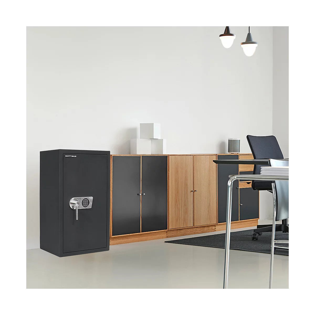 Schwarzer Tresor in einem Büro. Nebenan ein Schrank mit Schublade. Im Hintergrund weitere Schränke und ein Schreibtisch.