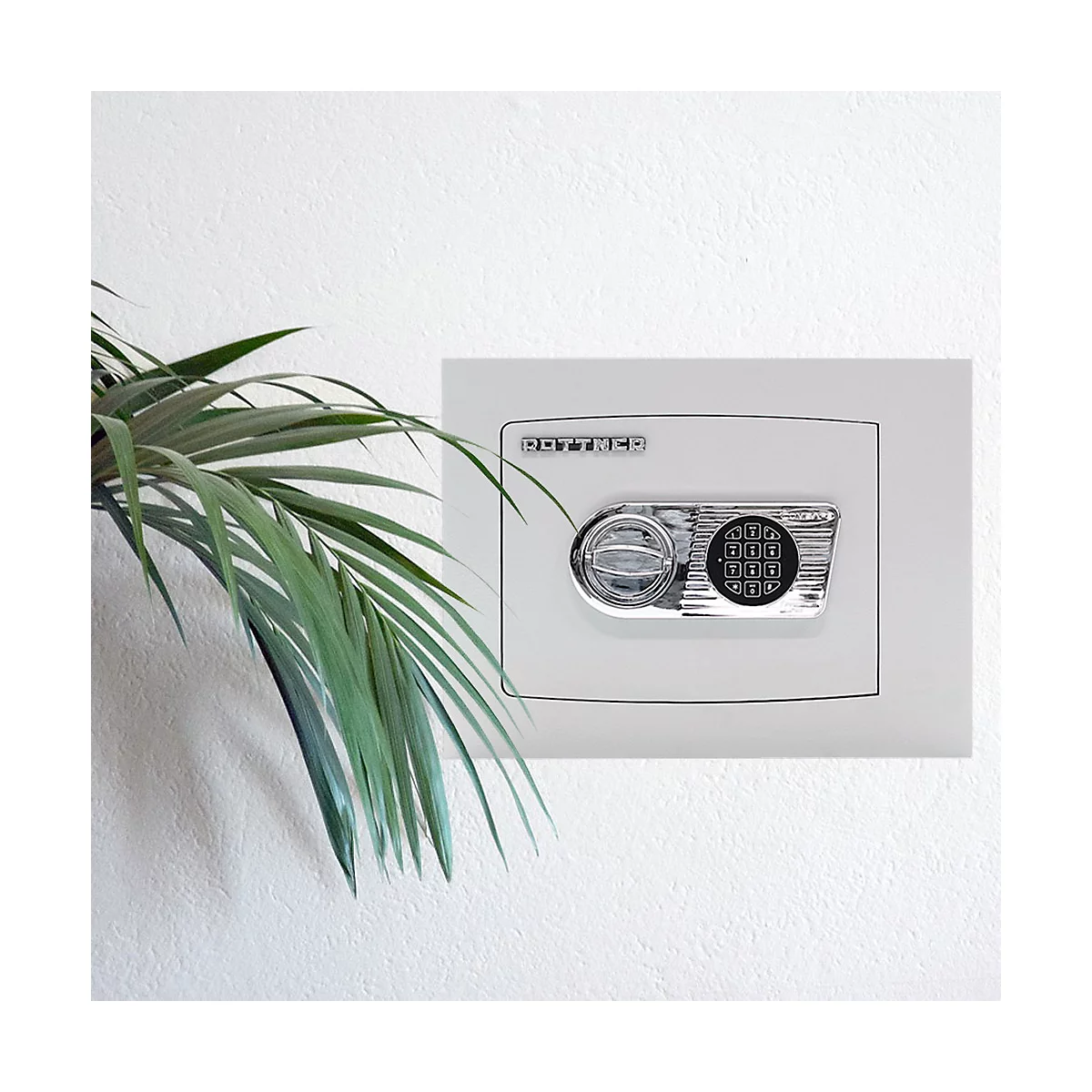 Ein weißer Safe mit Zahlenschloss an der Wand. Daneben grüne Blätter einer Zimmerpflanze.