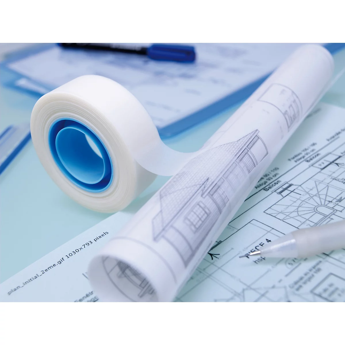 Gros plan sur du ruban adhésif et des plans. Papier enroulé avec dessin de maison et stylo.