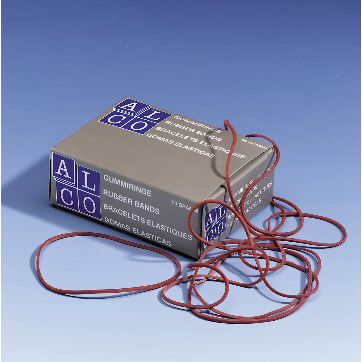 Gray box with red rubber bands. Inscription: Gummiringe, Rubber Bands, Bracelets Elastiques, Gomas Elasticas.