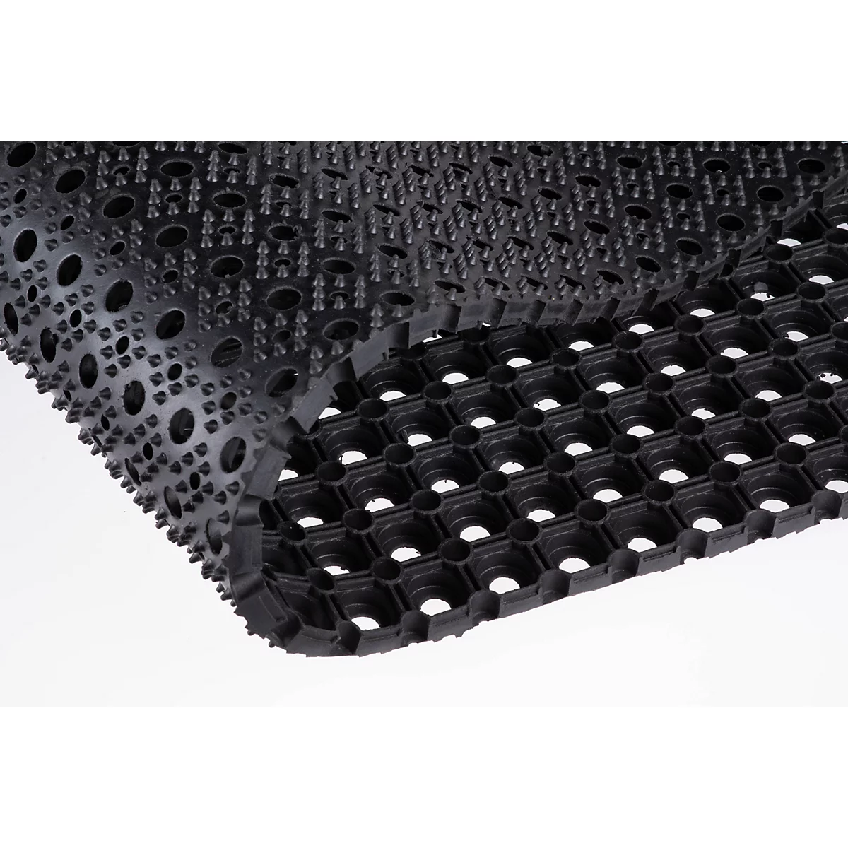 Close-up van een zwarte rubberen ringmat met een noppenstructuur.