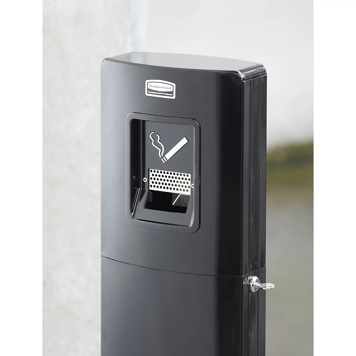 Schwarzer, säulenartiger Aschenbecher mit Rauchersymbol. Aufschrift: Rubbermaid. An der Seite ein kleiner Metallhebel.