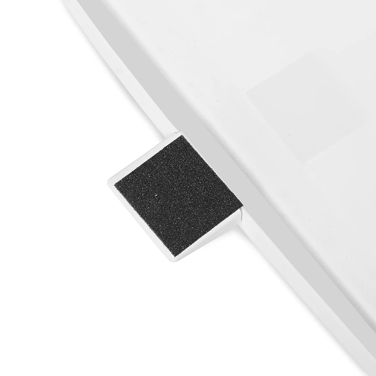 Detailaufnahme von einem weißen Objekt mit einem schwarzen, rechteckigen, strukturierten Element.