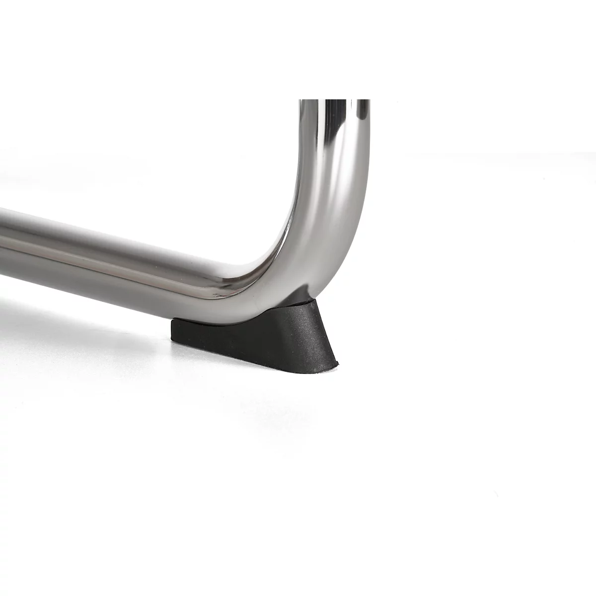 Close-up: curved metal foot with black rubber buffer.