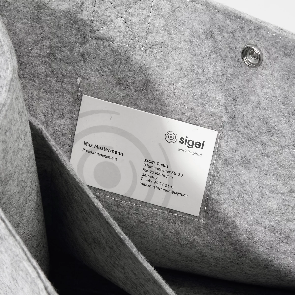 Sac en feutre gris avec une carte de visite portant le logo Sigel à l'intérieur. Il y a deux compartiments sur la gauche.