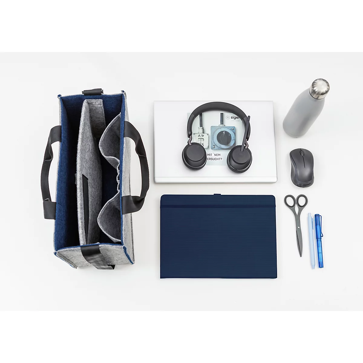 Sac bleu foncé, ordinateur portable, casque, souris, bouteille d'eau, bloc-notes, stylos et ciseaux.