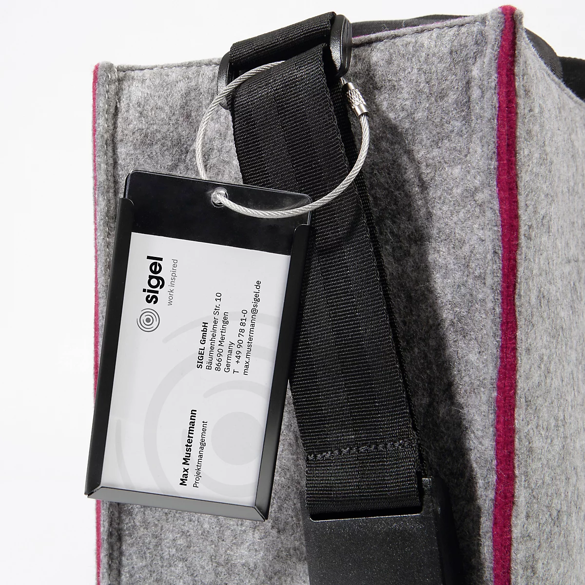 Sac en feutre gris avec sangle noire. Une étiquette nominative avec le logo de l'entreprise est accrochée au sac.