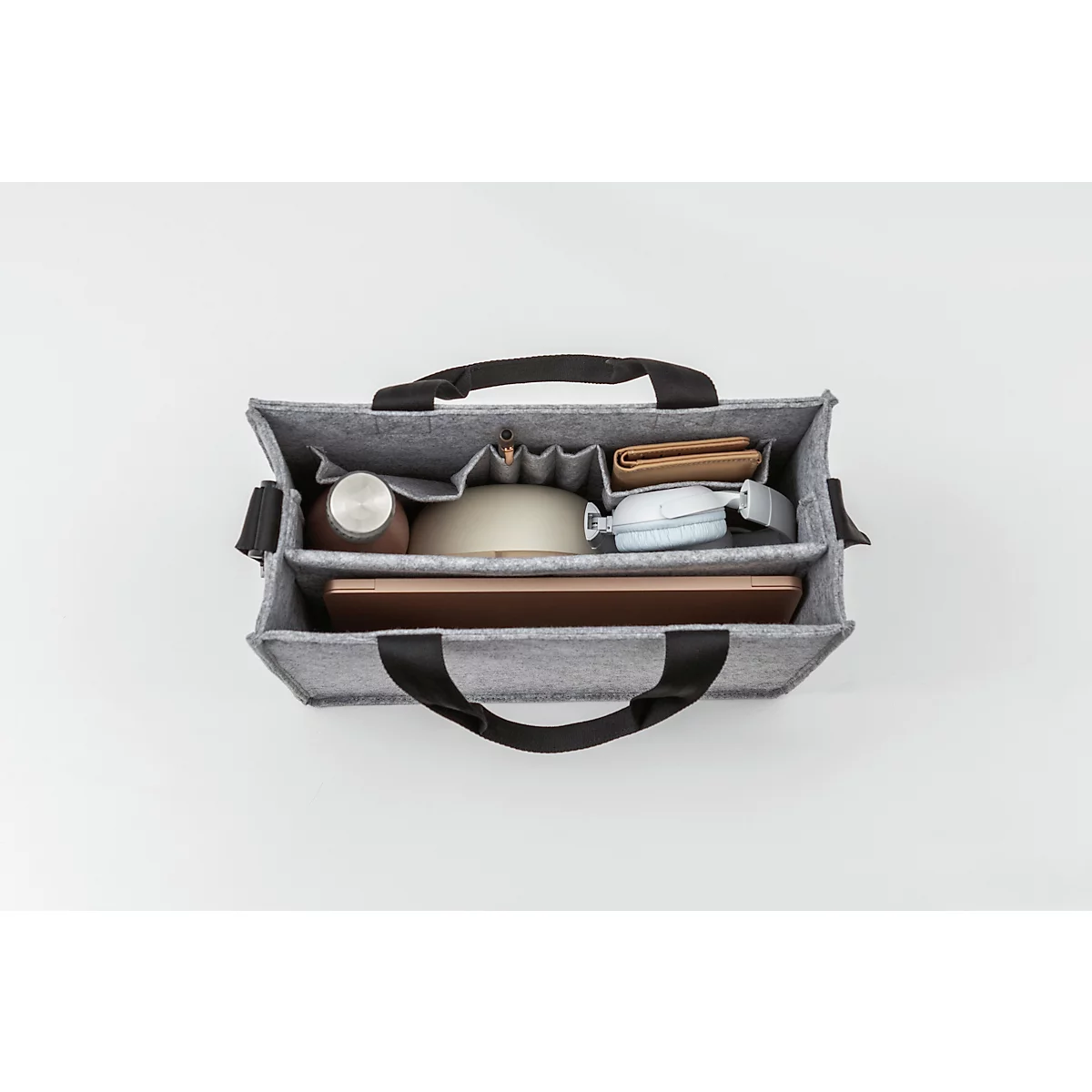 Sac fourre-tout en feutre gris avec poignées noires, rempli d'un ordinateur portable, d'un casque, de stylos et d'un portefeuille.