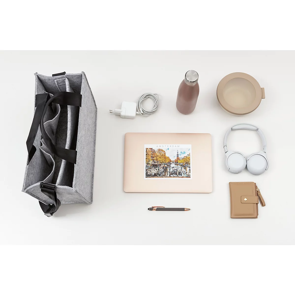 Sac en feutre gris avec fournitures de travail: ordinateur portable avec autocollant, casque, bouteille d'eau, stylo, portefeuille, bol, chargeur.