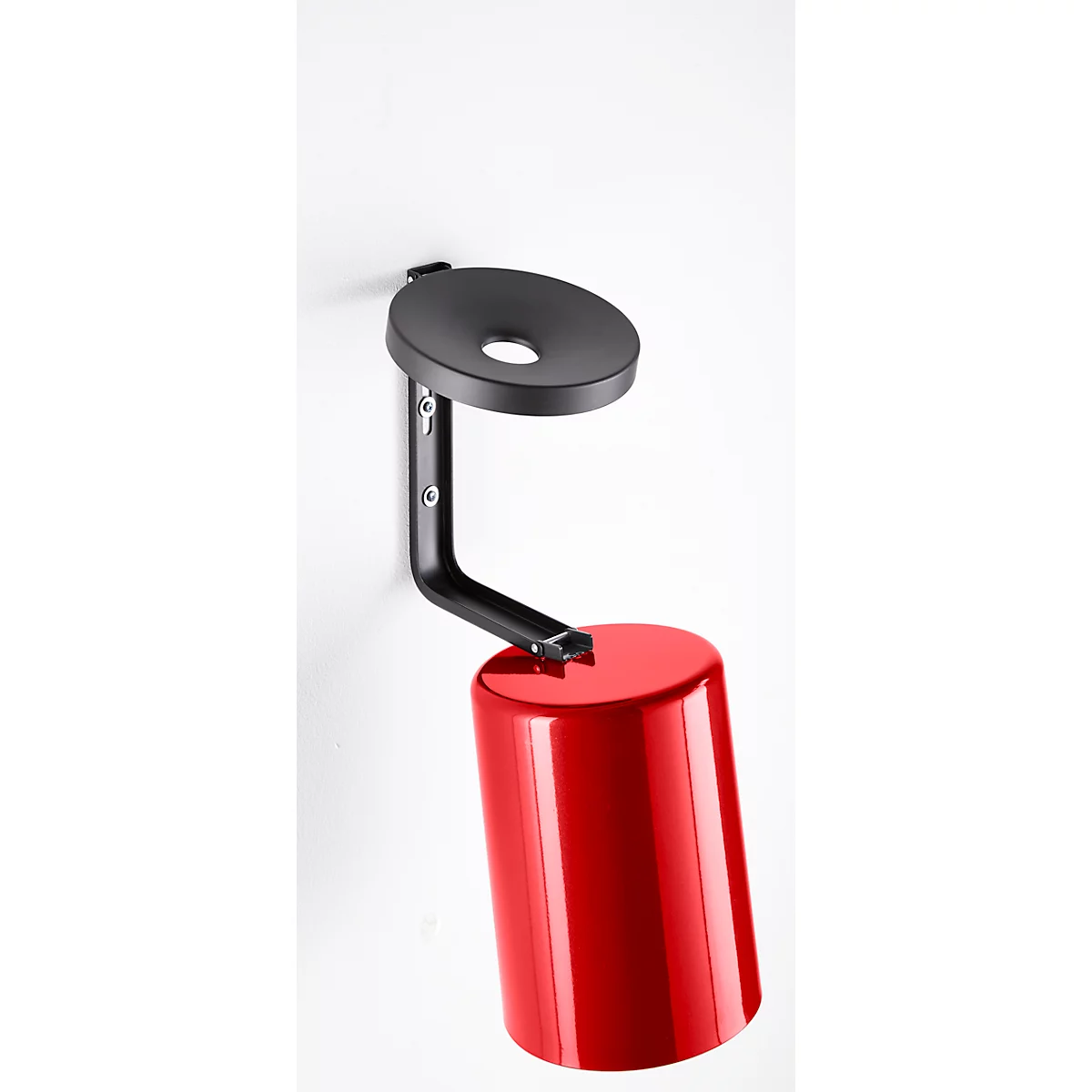 Red cylindrical wall lamp with black holder. A round, black mount is attached to a white wall.