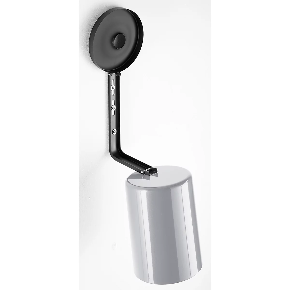 A wall lamp, consisting of a black, circular reflector mounted above a cylindrical, gray lampshade.