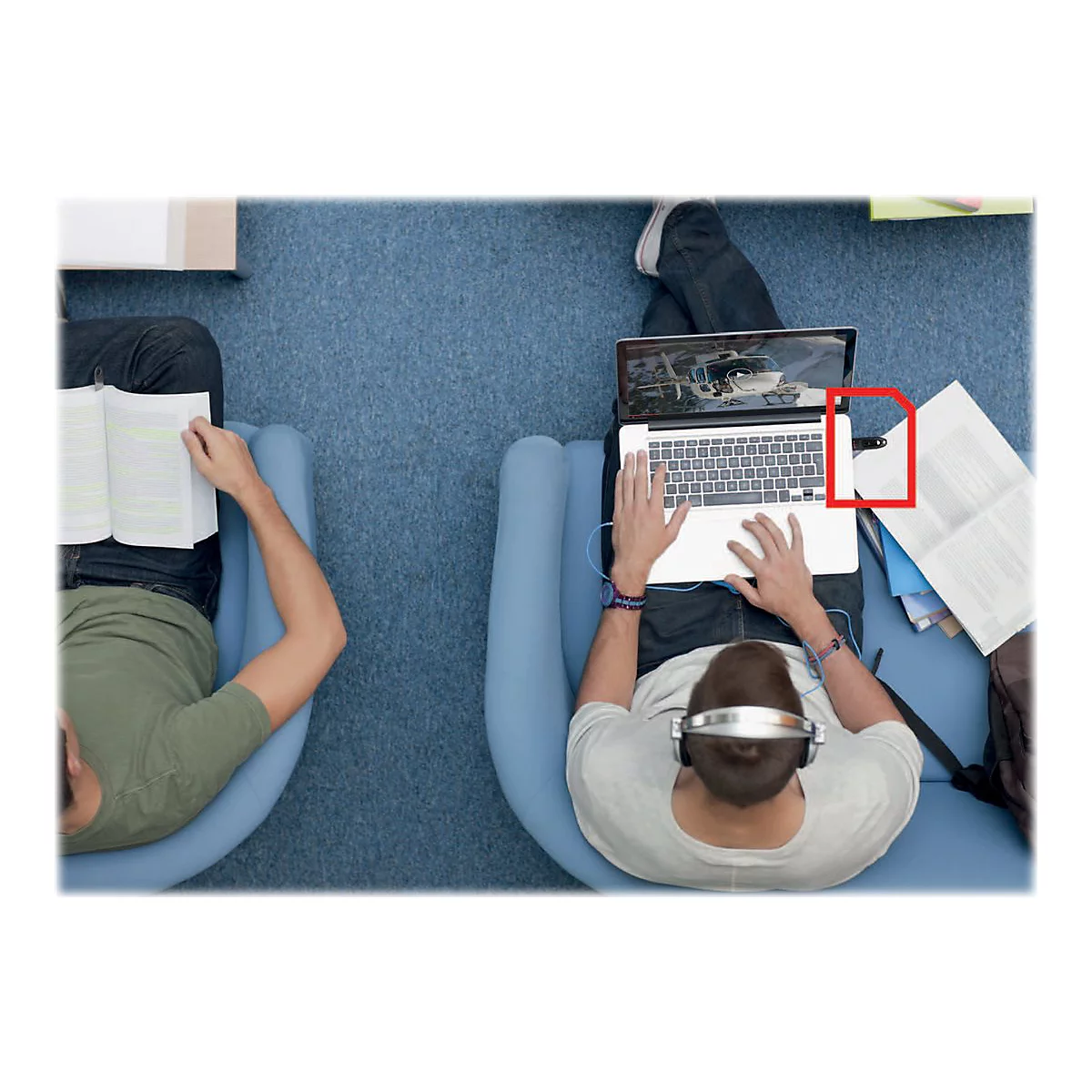 Deux personnes dans des fauteuils. L'une lit un livre, l'autre travaille avec un ordinateur portable, un casque et une clé USB.