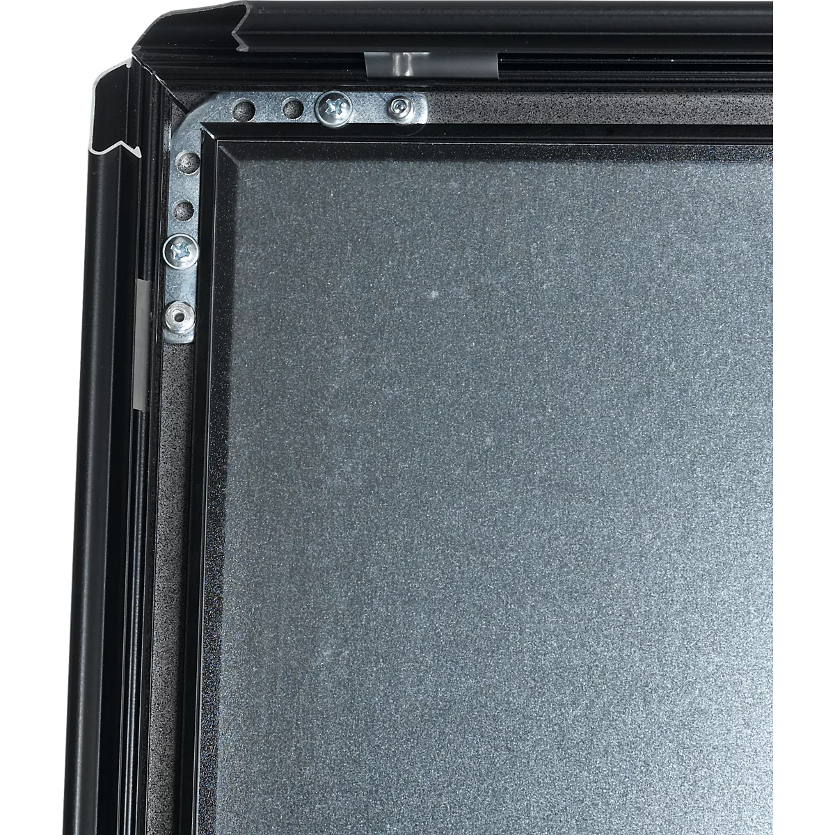 Close-up of a black frame construction with silver screws and gray surface.