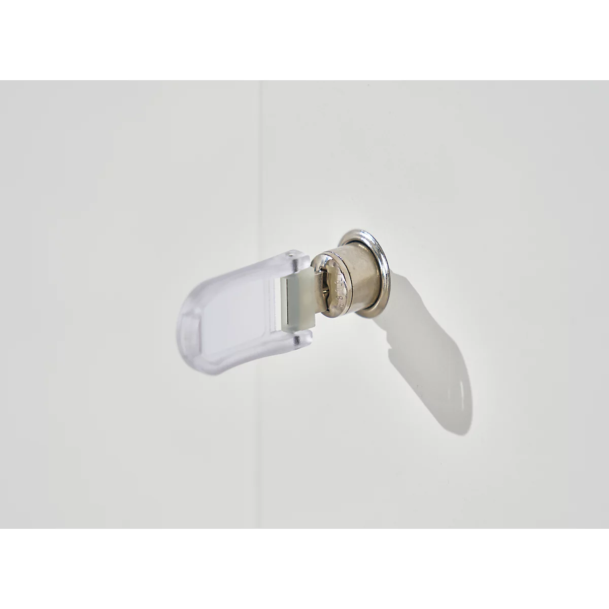Primer plano de una llave insertada en una cerradura con una carcasa rectangular transparente.