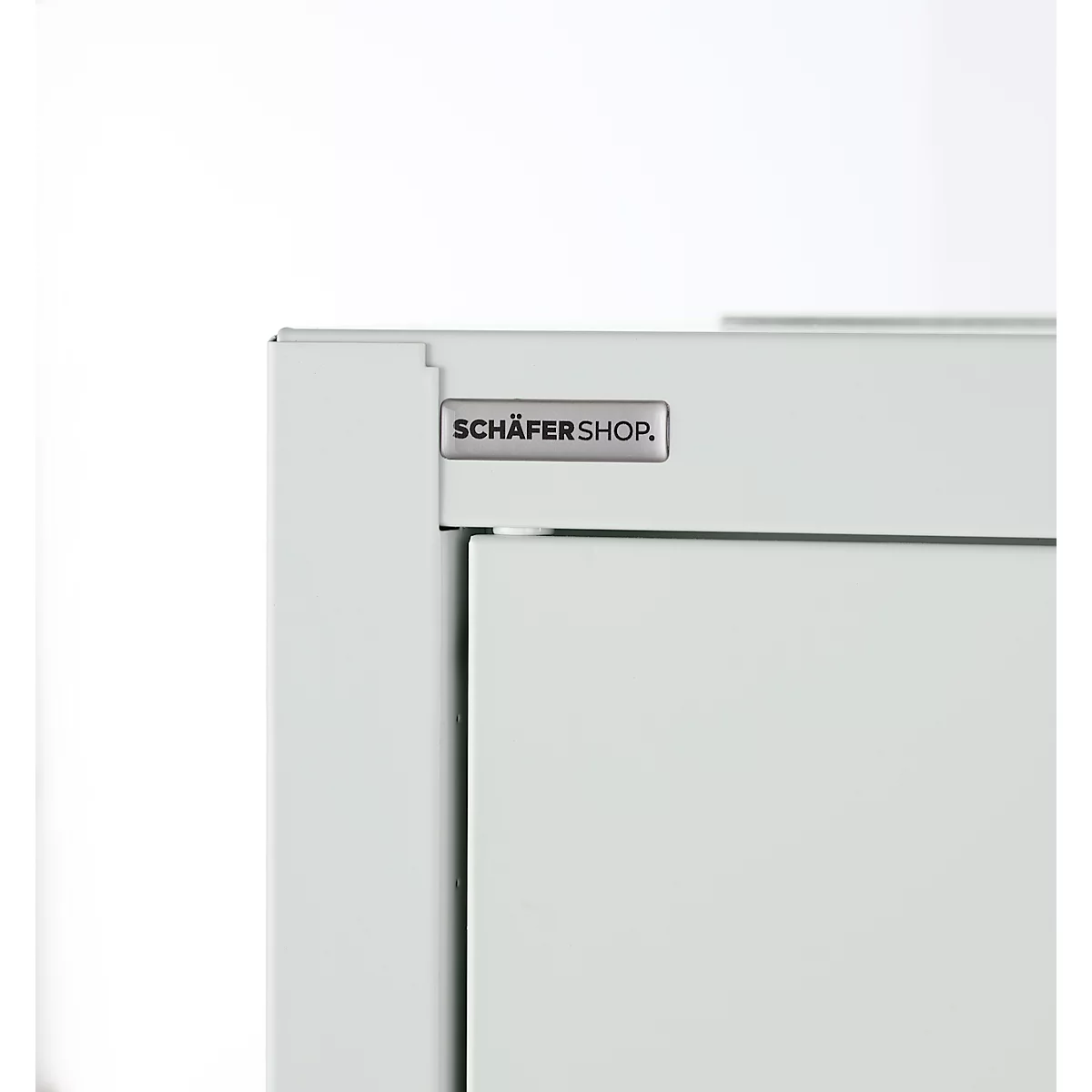 Gros plan d'un coin d'armoire blanc avec le logo "SCHÄFERSHOP".