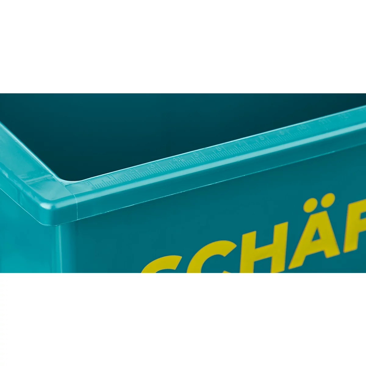 Gros plan d'une boîte turquoise avec l'inscription jaune 'SCHÄ'.