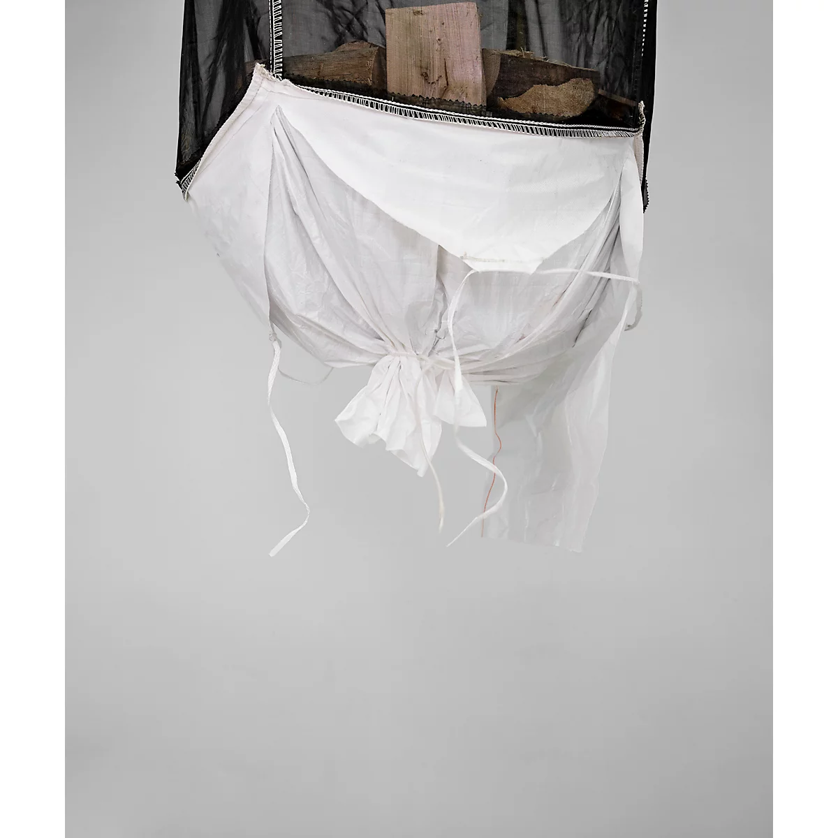 Objet rempli de bois. Un tissu noir entoure un tissu blanc noué avec des rubans pendants.