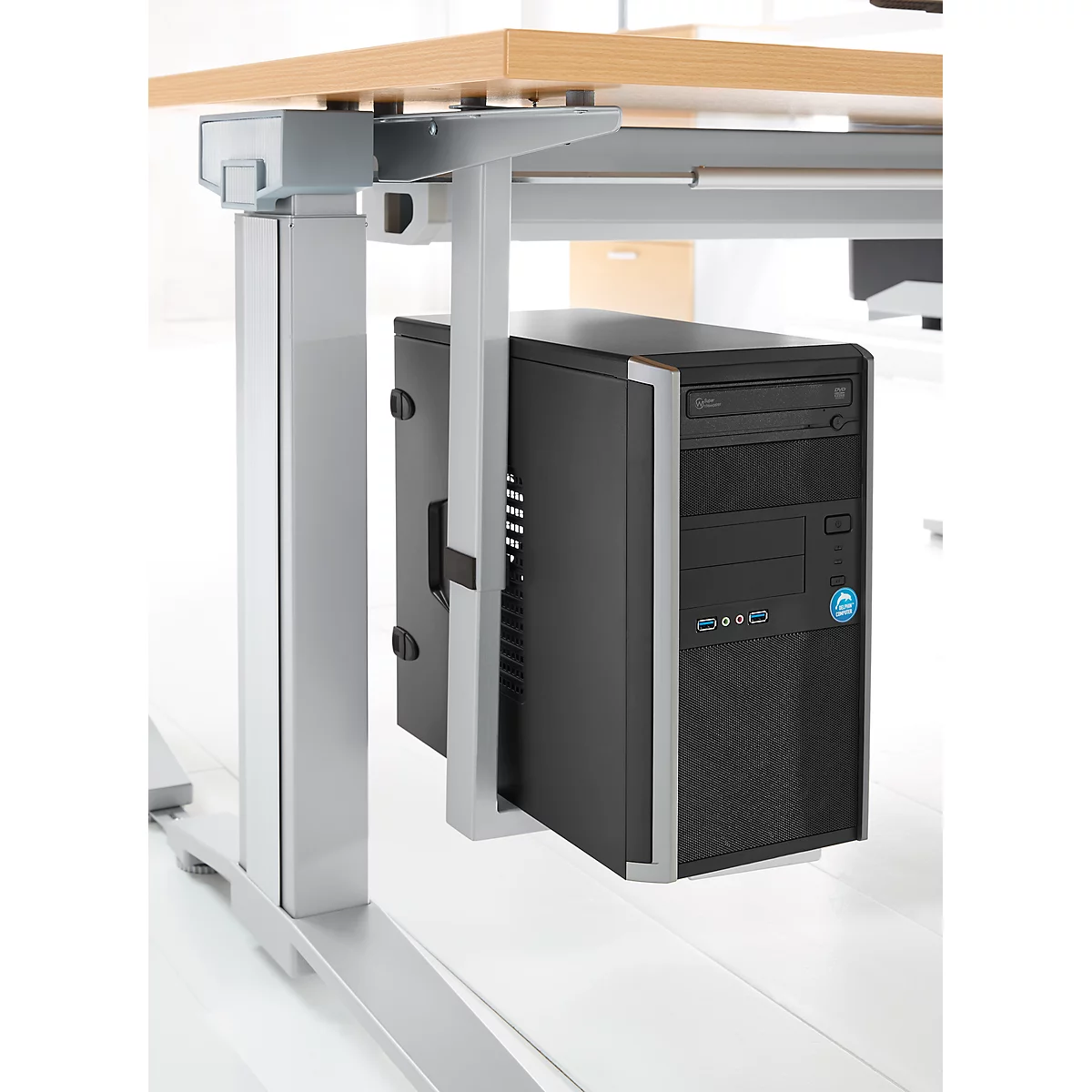 Een zwarte pc is gemonteerd onder een in hoogte verstelbaar bureau.