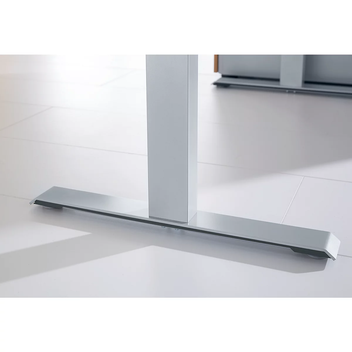 Detail of an office table foot. A rectangular, silver-gray base supports the white table column.
