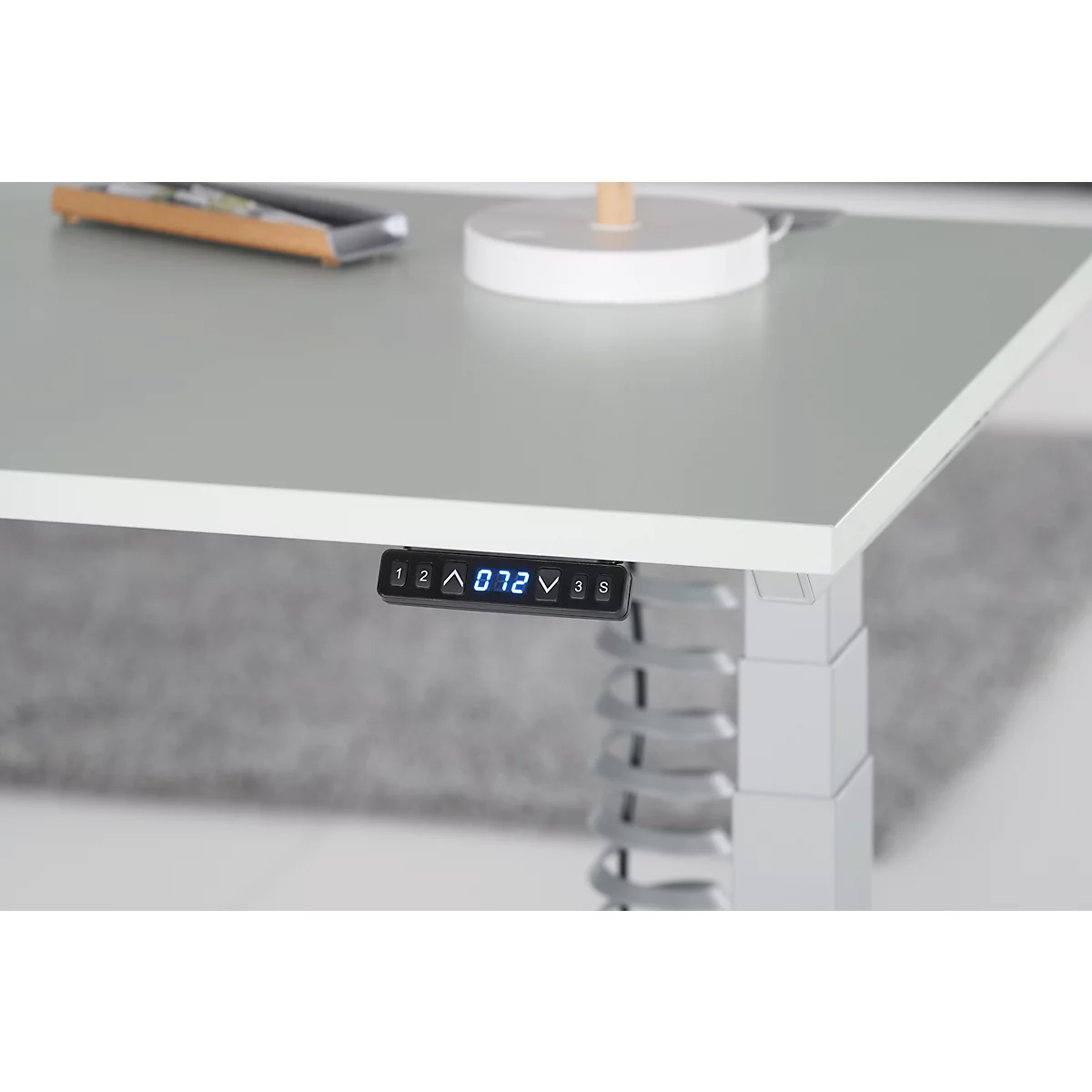 Close-up of a height-adjustable desk. A digital display shows the height.