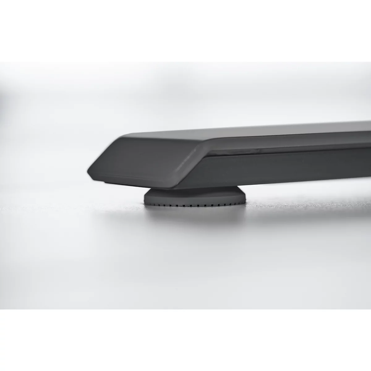 Dark gray table leg with a detailed foot plate. Clear design, good workmanship, minimalist background.