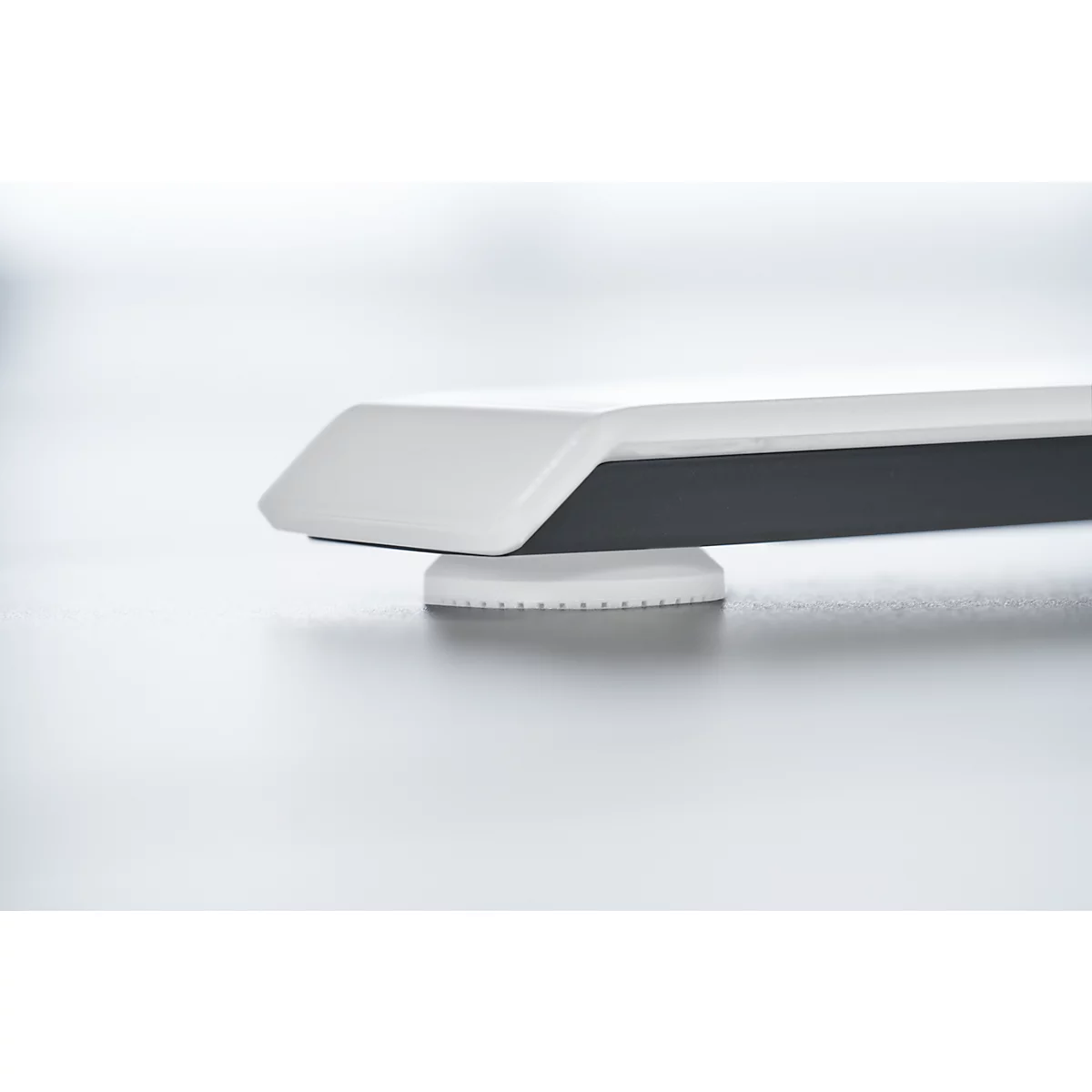 Detail: White table leg with black insert, resting on a white base.